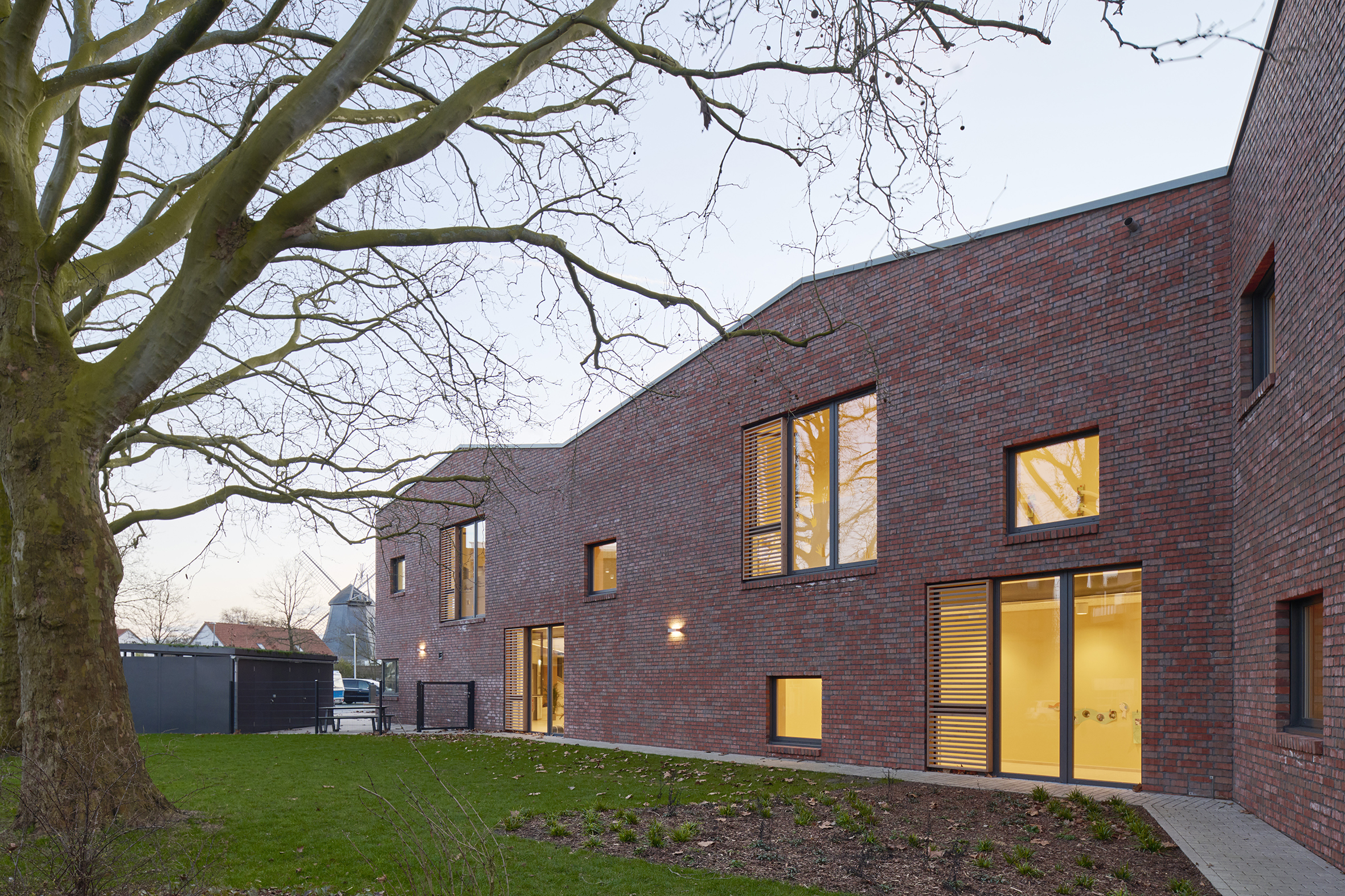 Kita Buchholzer Grün Außenansicht mit wiederkehrendem Giebelmotiv und Grünfläche