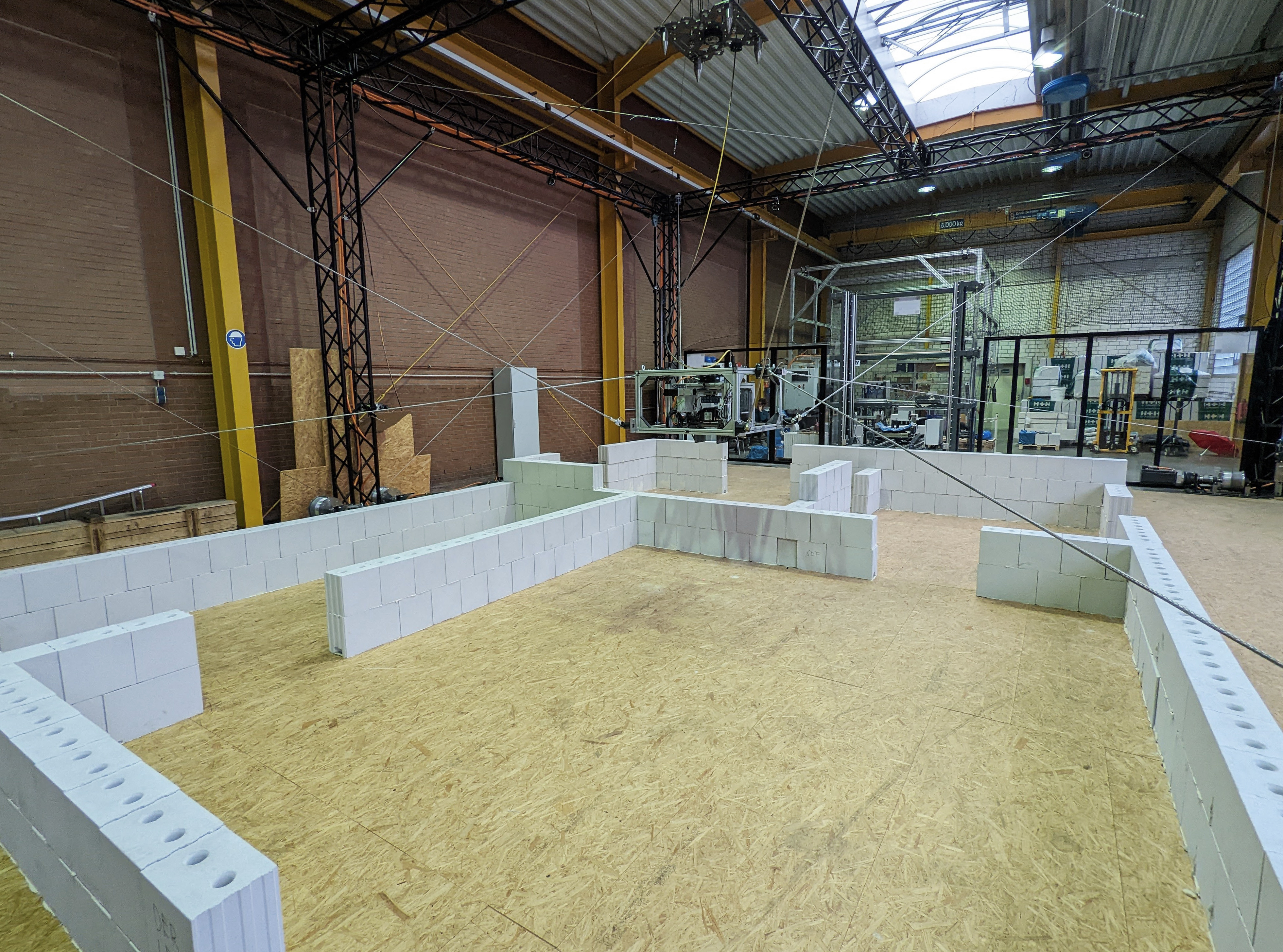 Seilroboter erstellt eigenständig Mauerwerk in Halle