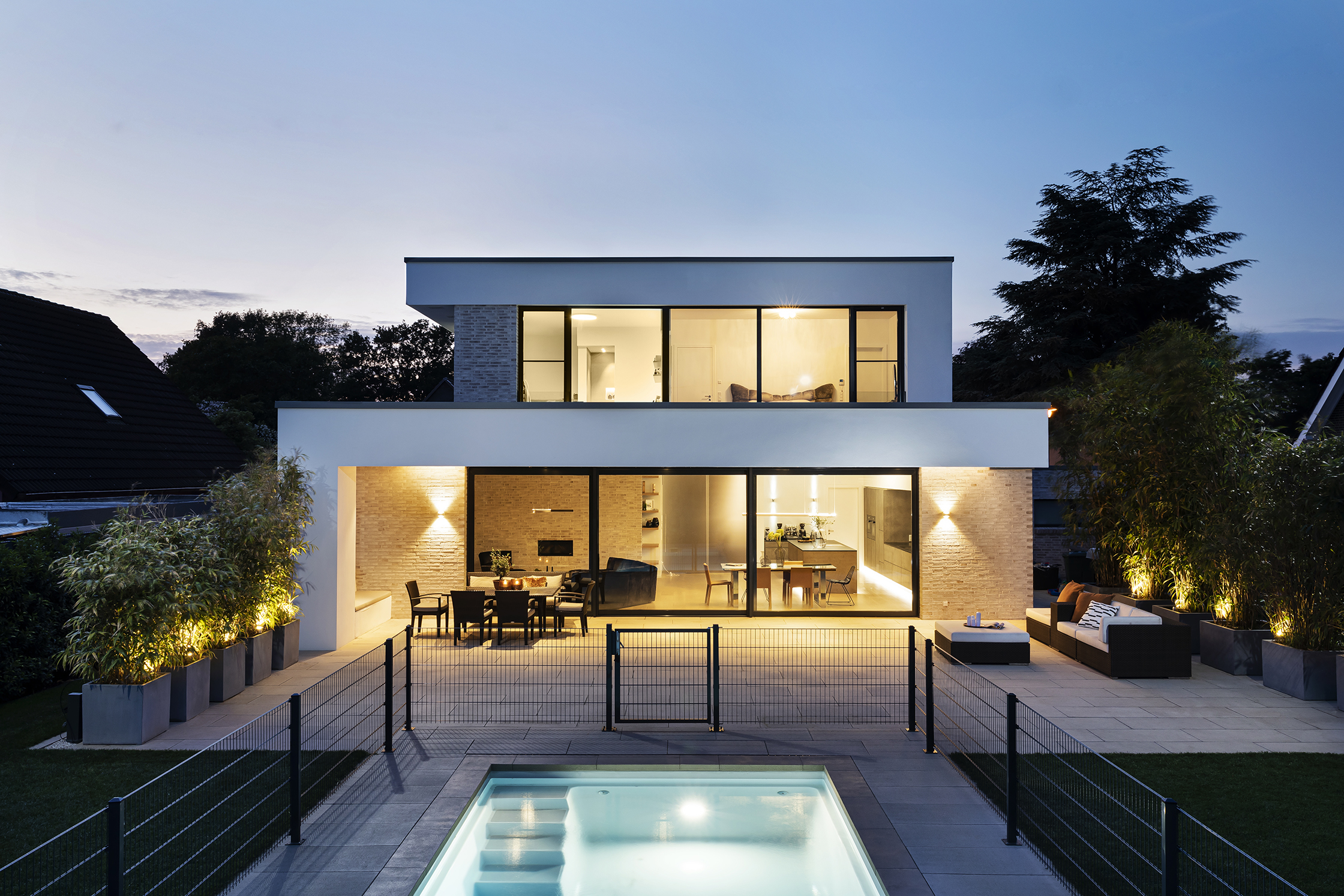 Haus H Gartenansicht Rückansicht mit Pool in der Abenddämmerung Haus H Gartenansicht Rückansicht mit Pool in der Abenddämmerung