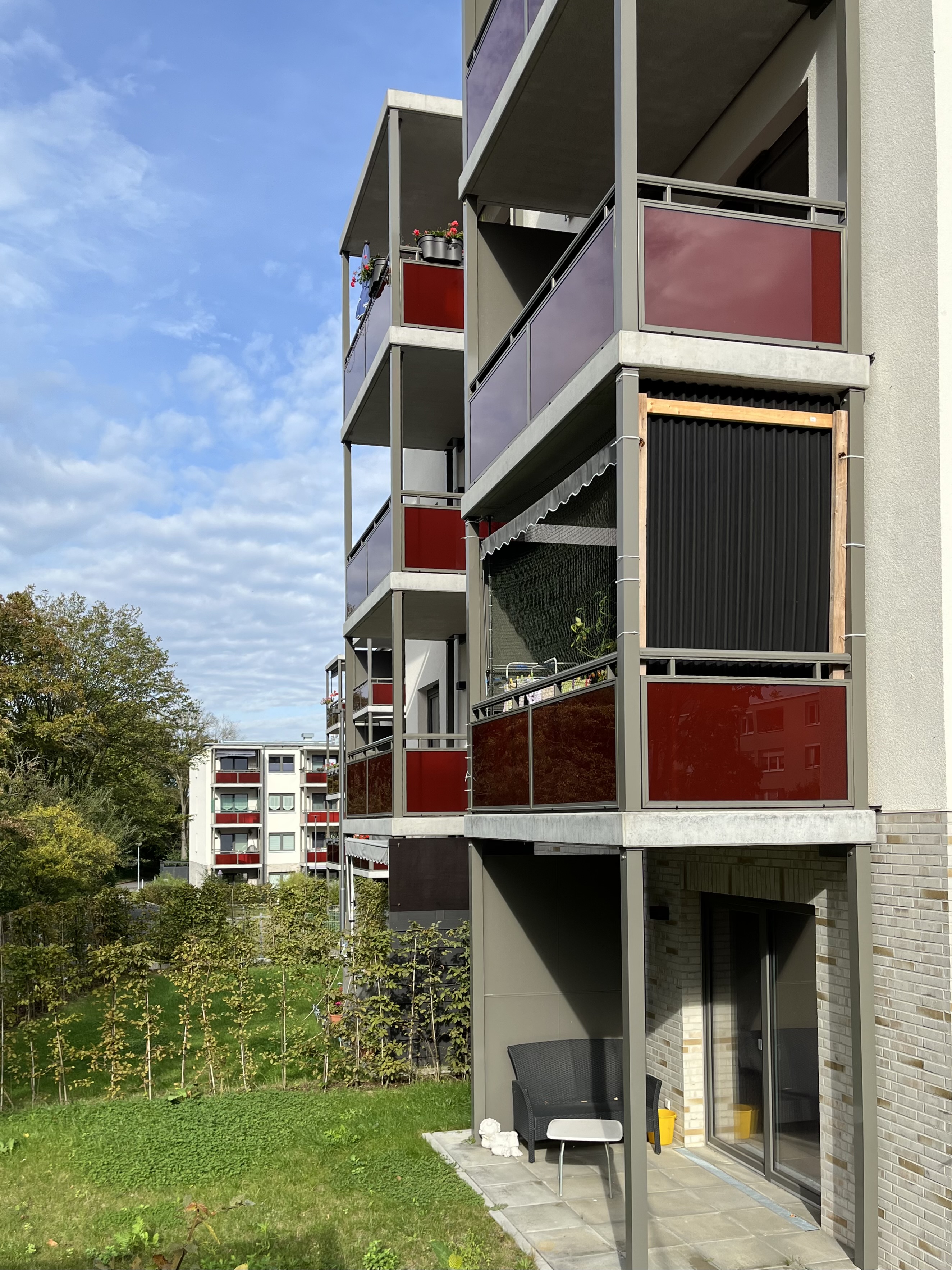 Wohnen für alle Neuland Wolfsburg rote Balkone und Grünfläche