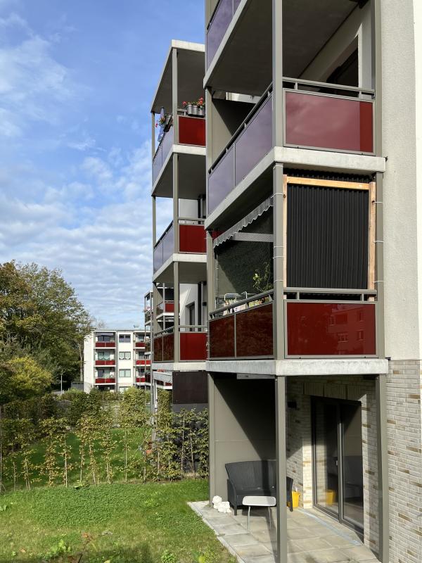 Wohnen für alle Neuland Wolfsburg rote Balkone und Grünfläche